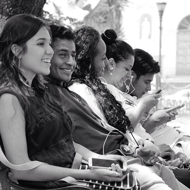 A group of friends ‘chatting’ with each other on a bench of Parque Central, La Antigua Guatemala