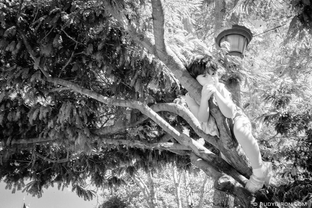 Peekaboo — A little girl sunbathing on a tree at Parque Central, Antigua Guatemala