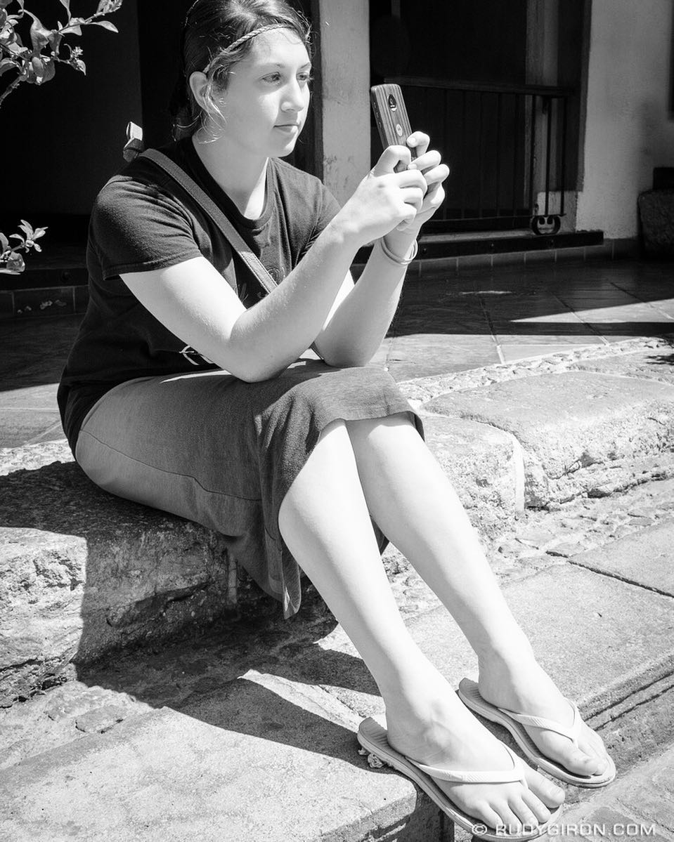 Street Photography — Mennonite girl grabing some snapshots of her visit to Antigua Guatemala.