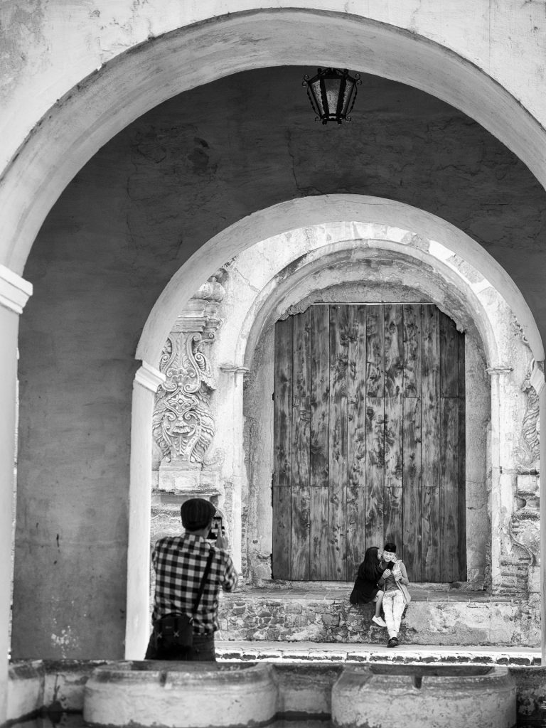 #StreetPhotography — Kissing couple framed within three sets of arches in Antigua Guatemala by RUDY GIRON
